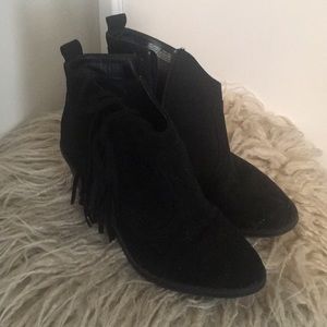 Trendy black boots with side tassels.